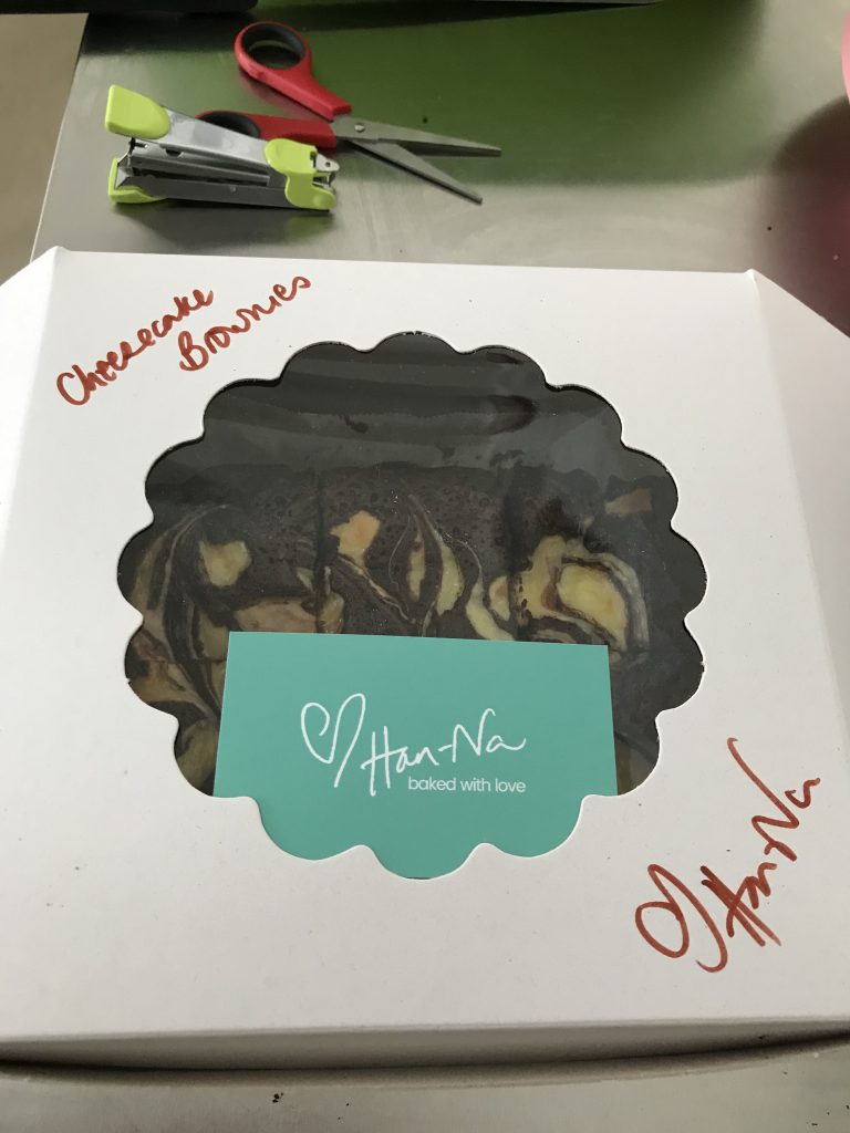 cake box with cheesecake brownies inside, a green business card with love, Han-Na