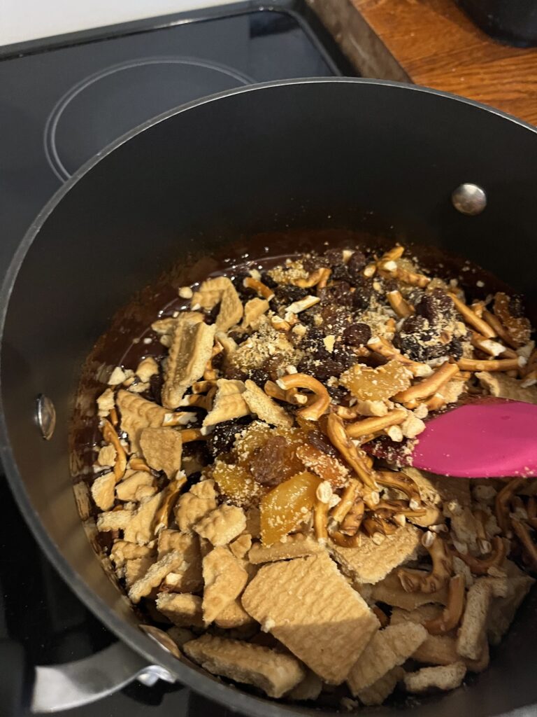crushed biscuits, dried fruit and nuts being mixed into melted chocolate, golden syrup and butter